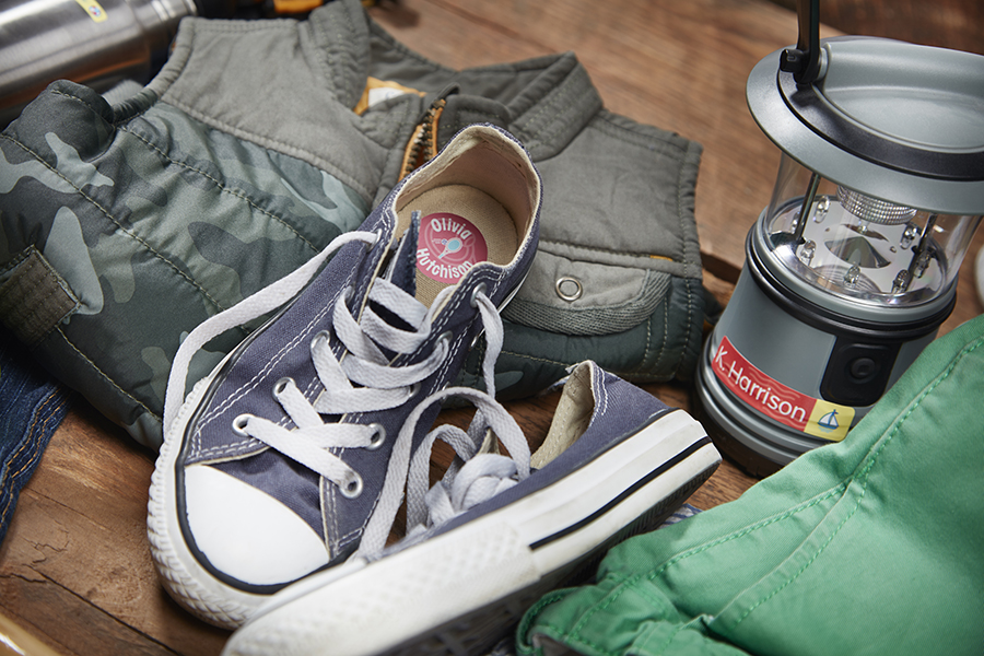 Camp items including thermos, shoes and vest with prominent mabels labels with children's names.