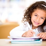 young girl smiling and studying for school
