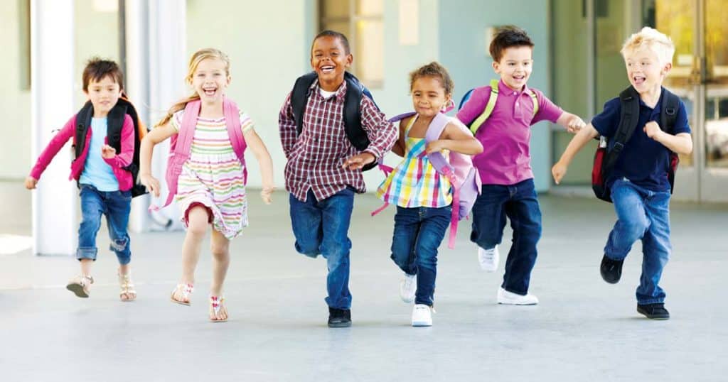 children with backpacks running