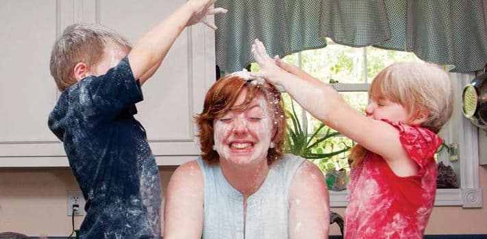 family activity - children pouring flour on mom