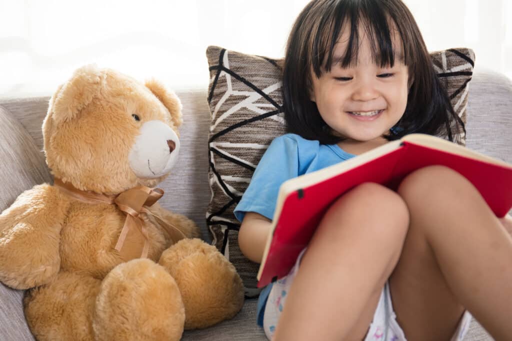 child reading to stuff toy
