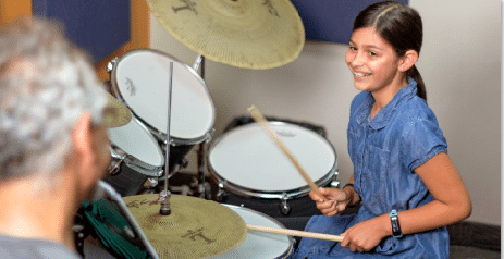 girl playing music on drums
