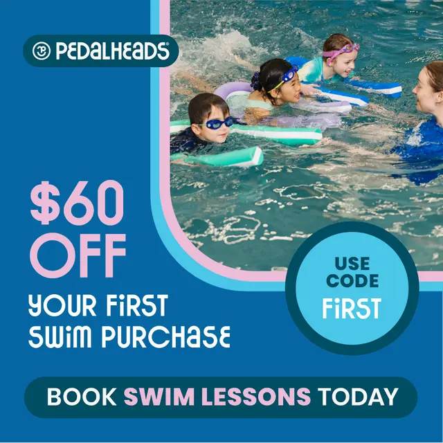 Girl swimming instructor in pool with three kids on floatation boards.