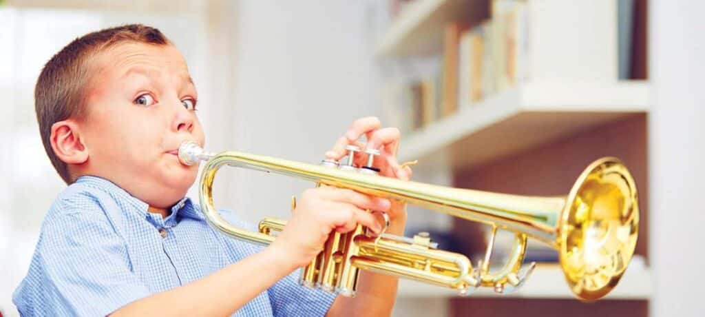 boy playing trumpette instrument