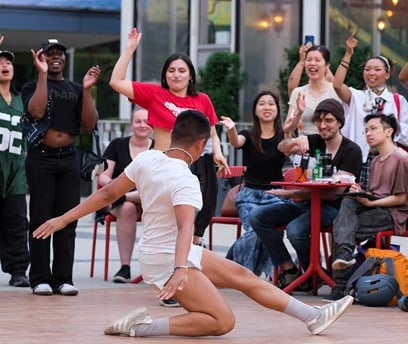 A person break dancing in front of a crowd.